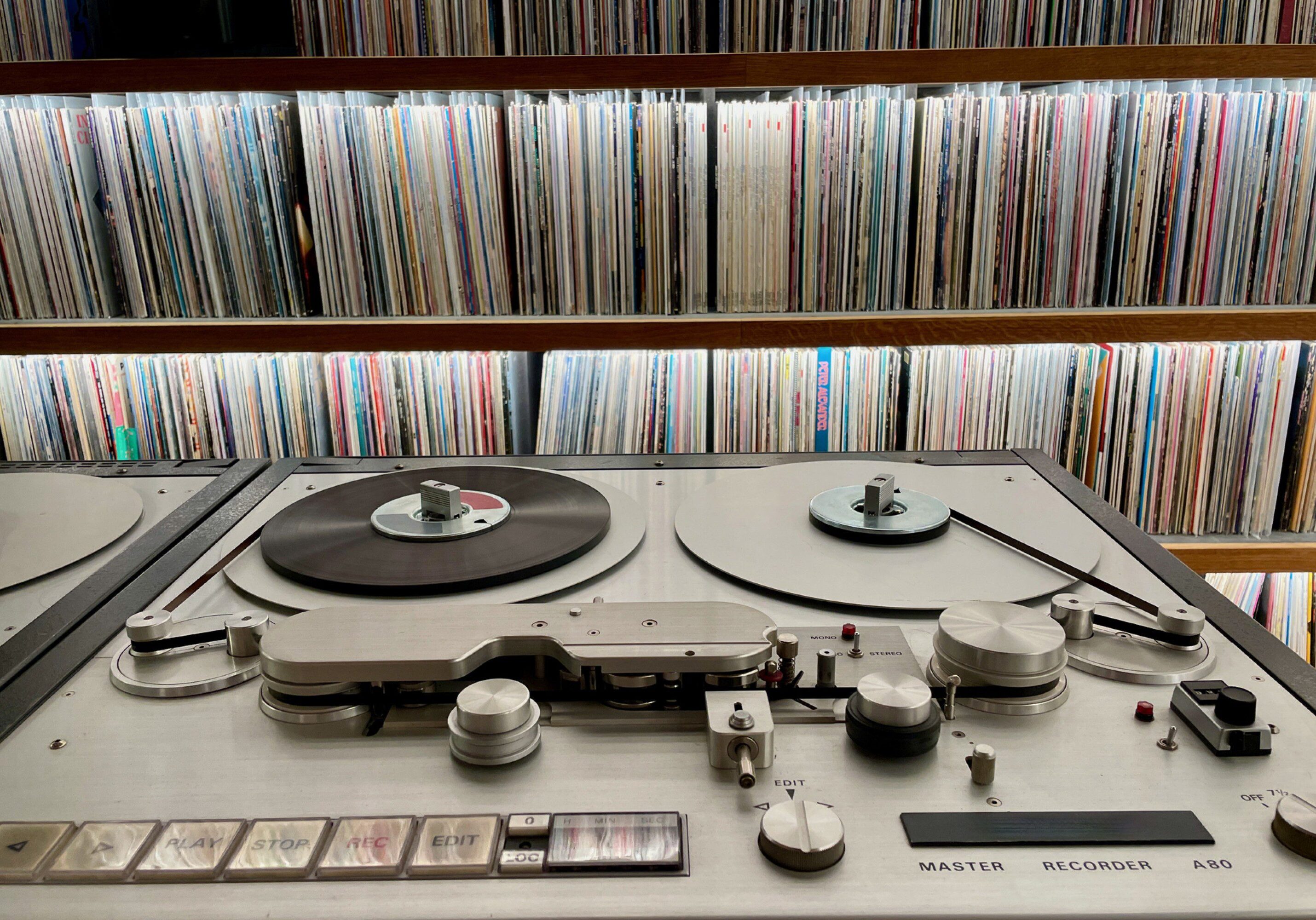 Vintage reel-to-reel tape recorder and records.